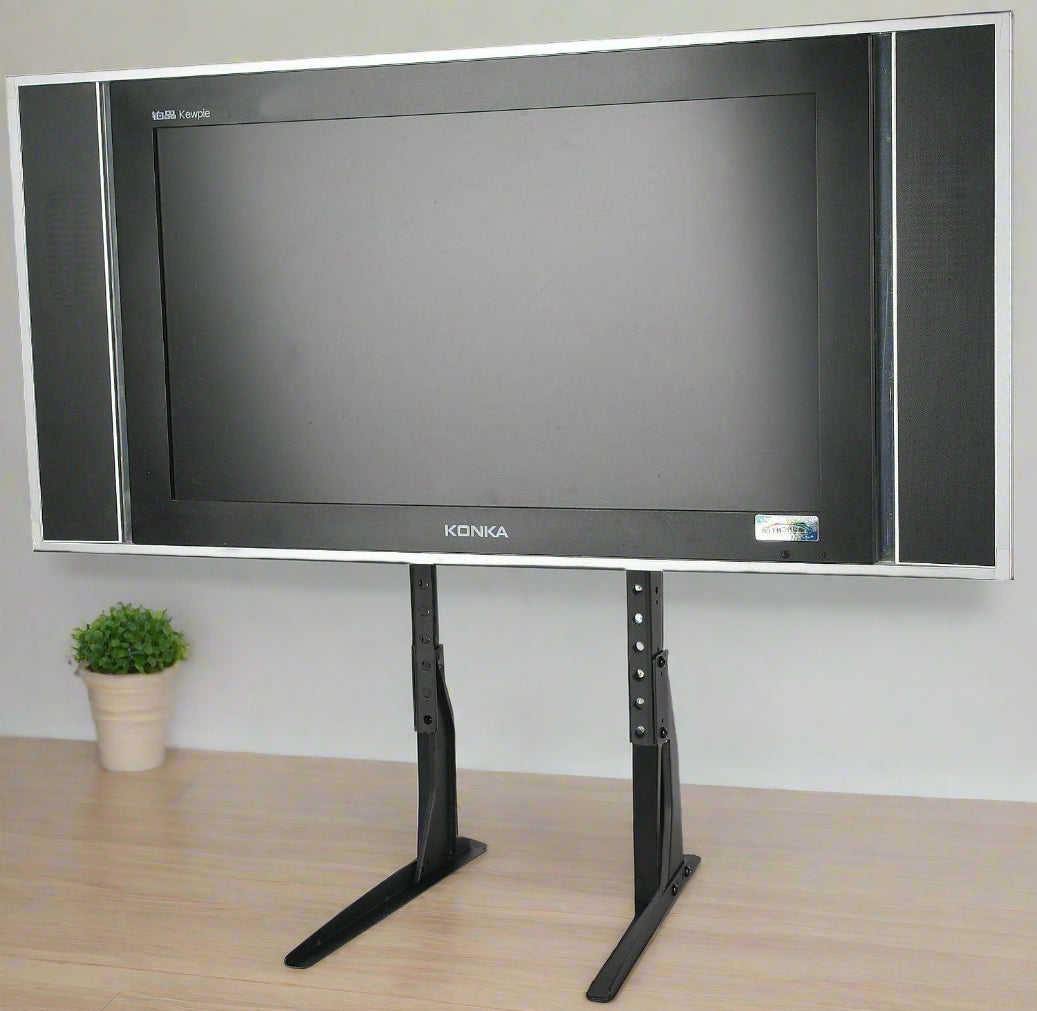 Universal black TV riser stand for 32 to 60 inch TVs
Side view of matte black adjustable TV desk mount
VESA-compatible desk mount for flat-screen TVs
TV stand setup for monitor or entertainment center use
Adjustable height tabletop TV stand with rubber feet