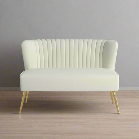 Fuchsia velvet loveseat with tufted back and gold legs in modern decor.
Ivory armless loveseat sofa with mid-century design in studio setup.
Tan velvet 2-seater with flared gold legs styled against a neutral wall.
Close-up of plush velvet texture and fluted backrest detail.
Color swatches displaying Fuchsia, Pink, Ivory, and Tan options.