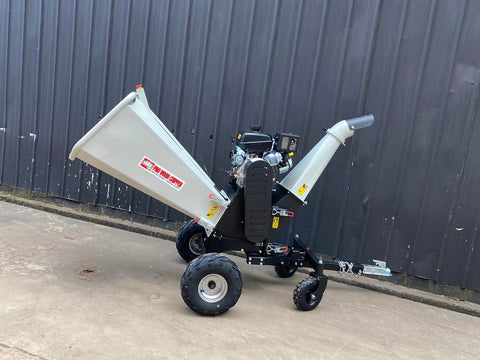 15 HP Kohler electric start wood chipper – trailer mounted front view
Side profile of 420cc wood chipper with hitch and tires
Chipper machine close-up showing large intake chute and rotor
Kohler engine wood chipper parked outdoors with debris