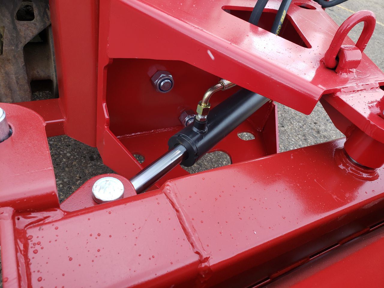 Skid steer clearing snow using Bendall hydraulic snow plow
Bendall 96” red snow plow angled to the side
Close-up of adjustable skid shoes and hydraulic fittings
Rear view of snow blade attached to skid steer
Bolt-on reversible cutting edge on Bendall plow