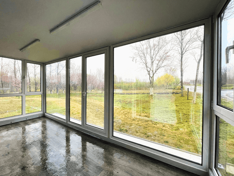 Expandable glass container house with black frame and white kitchen interior
20ft high cube glass container house on an outdoor plot
Modern prefab modular container home with large glass walls
Inside view of the container house kitchen and bathroom setup
portable luxury container home with plumbing and wiring