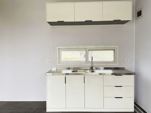 Expandable glass container house with black frame and white kitchen interior
20ft high cube glass container house on an outdoor plot
Modern prefab modular container home with large glass walls
Inside view of the container house kitchen and bathroom setup
portable luxury container home with plumbing and wiring