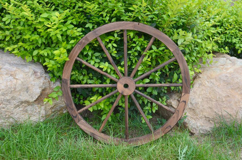 "Rustic wooden wagon wheel 48 inch for garden decor"
"Burnt wood wagon wheel leaning against a fence"
"Farmhouse yard display with decorative wooden wheels"