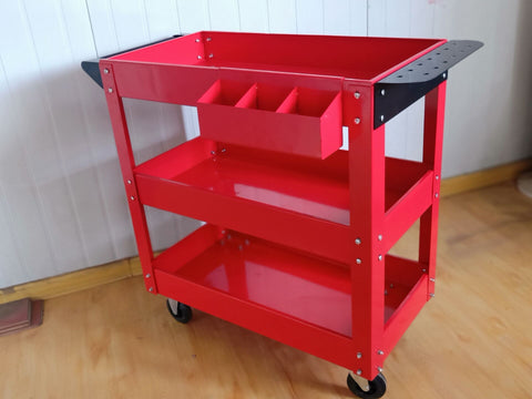 3-layer red steel rolling tool cart with swivel casters and ergonomic handle.
Mobile shop equipment cart with deep trays for tool storage