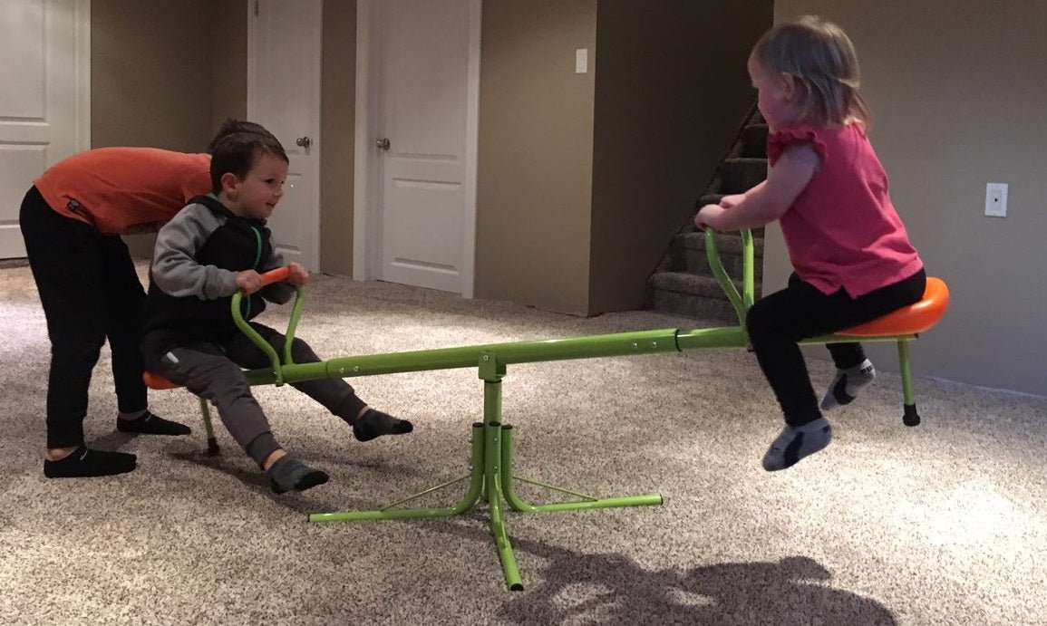 Kids spinning on green 360° seesaw in backyard
360-degree rotating seesaw with blue seats and soft handles
Outdoor seesaw with rotation and bounce action
Side view of children playing on rotating seesaw
Playground toy for toddlers and young kids