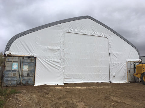 50x80 ft all-white PVC double truss fabric shelter installed over shipping containers β heavy-duty industrial storage building