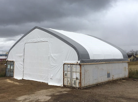 50x80 ft all-white PVC double truss fabric shelter installed over shipping containers β heavy-duty industrial storage building