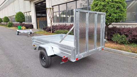 "5x8 galvanized utility trailer with built-in ATV ramps"
"Rust-resistant utility trailer parked near grass lot"
"Heavy-duty galvanized trailer with side view of ramps"