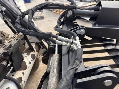 72" hydraulic grapple bucket on skid steer
Skid steer rock grapple front view
Close-up of grapple teeth and hoses
Dual-cylinder grapple open position
Grapple attachment lifting heavy debris