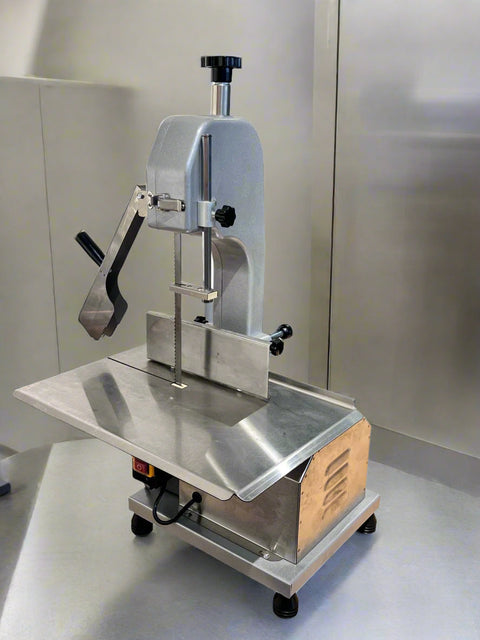 Full front view of a commercial frozen meat and bone saw machine
Side angle of a stainless steel cutting saw in a commercial kitchen
Bone saw machine in use, cutting frozen meat
Operator slicing frozen beef bones with an electric meat saw
Commercial food processing bone cutting equipment in operation
Close-up of adjustable blade on automatic bone saw