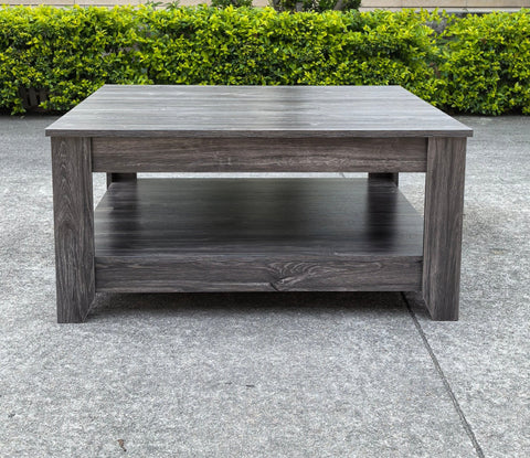 Dark gray oak square coffee table styled in a modern living room
Close-up of woodgrain texture and lower shelf
Angled view of the full table with storage items
The coffee table is placed with decorative accessories
Dark oak coffee table with books and a remote on the shelf