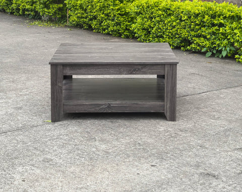 Dark gray oak square coffee table styled in a modern living room
Close-up of woodgrain texture and lower shelf
Angled view of the full table with storage items
The coffee table is placed with decorative accessories
Dark oak coffee table with books and a remote on the shelf