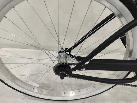Side view of Deviant 26" beach cruiser bicycle in matte black
Close-up of comfort seat and handlebar grips
Rear coaster brake and single-speed drivetrain
Full assembled view of the Deviant black cruiser bike
Cruiser bike parked on a path at sunset