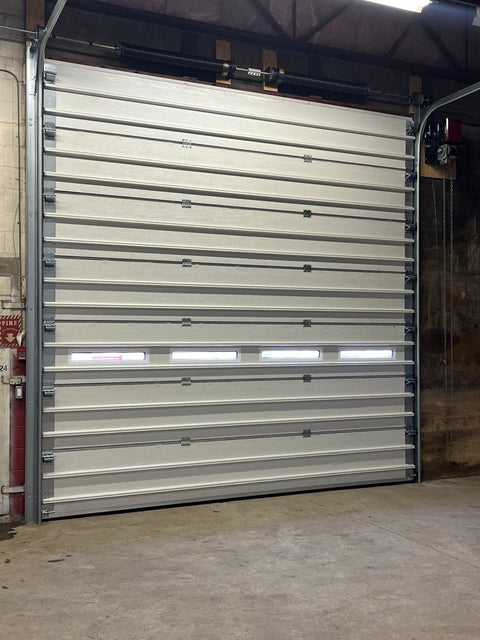 White insulated electric overhead garage door installed in shop
Heavy-duty motorized overhead garage door with steel frame
Electric garage door kit with insulation for industrial buildings
Overhead sectional garage door installed on warehouse