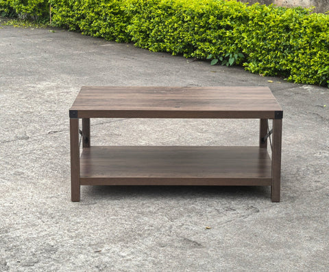 Gray wash rustic coffee table with metal X-frame in the living room
Front view of the coffee table showing shelf storage
Side angle showing gray tabletop and open shelf
Coffee table outdoors with accessories
Detail of gray wash wood and black frame