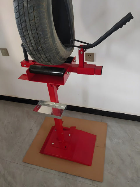 Manual tire changer and spreader stand with red base and swivel platform
Tire changer stand showing adjustable tilt function and tool tray
Manual tire repair stand for light truck tires in auto repair garage