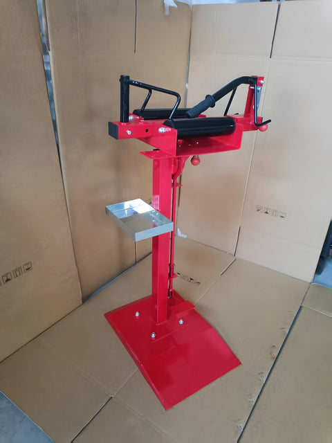 Manual tire changer and spreader stand with red base and swivel platform
Tire changer stand showing adjustable tilt function and tool tray
Manual tire repair stand for light truck tires in auto repair garage