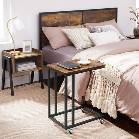 Rustic side table with laptop on top near sofa
Rolling wood TV tray with black metal legs
End table with wheels next to couch
Industrial-style side table for laptop and coffee