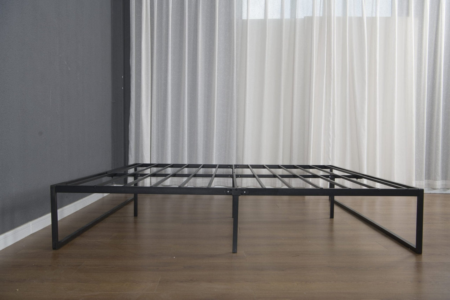 Metal platform bed frame assembled on wooden floor in modern space