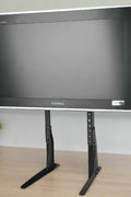 Universal black TV riser stand for 32 to 60 inch TVs
Side view of matte black adjustable TV desk mount
VESA-compatible desk mount for flat-screen TVs
TV stand setup for monitor or entertainment center use
Adjustable height tabletop TV stand with rubber feet