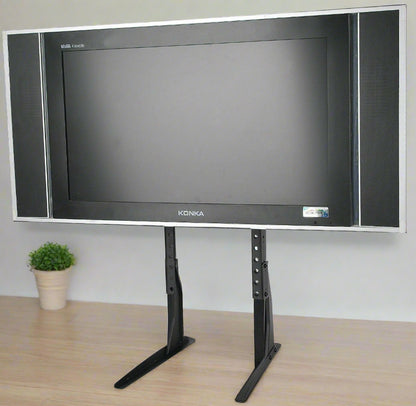Universal black TV riser stand for 32 to 60 inch TVs
Side view of matte black adjustable TV desk mount
VESA-compatible desk mount for flat-screen TVs
TV stand setup for monitor or entertainment center use
Adjustable height tabletop TV stand with rubber feet