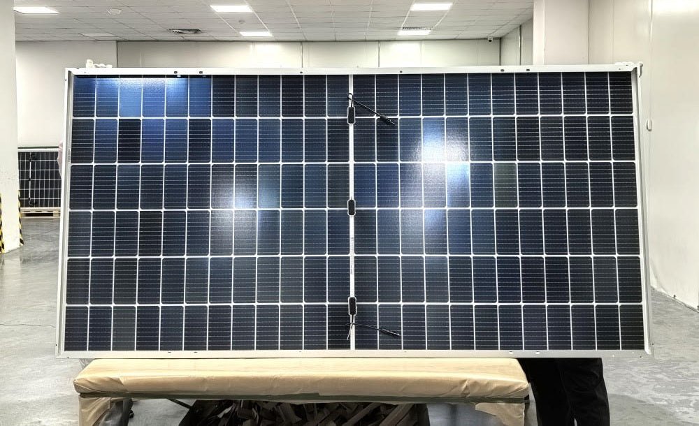 "565W bifacial monocrystalline solar panel front view"
"144-cell high-efficiency solar module close-up"
"Solar panel showing rear energy capture and wiring"
"Commercial-grade bifacial solar panel in warehouse"