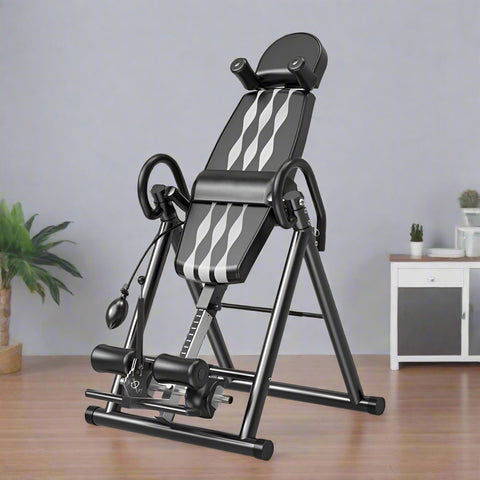 Folding inversion table for back pain relief and spinal decompression
Adjustable inversion table for home use and fitness therapy
Close-up of padded backrest and ankle support on inversion table
Foldable back stretcher in upright storage position
User on inversion table demonstrating full inversion angle