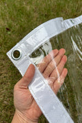 Heavy-duty clear PVC tarp showing reinforced grommet and transparent material