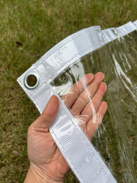 Heavy-duty clear PVC tarp showing reinforced grommet and transparent material