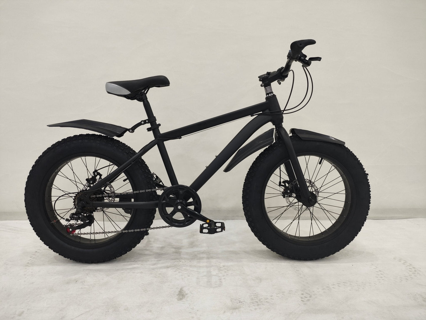 Deviant 20-inch fat tire off-road bike on the beach

Side view of 7-speed fat tire bike with disc brakes

Shimano derailleur on Deviant fat tire bike

Close-up of front disc brake and suspension fork

All-season fat tire bike on snow and gravel terrain