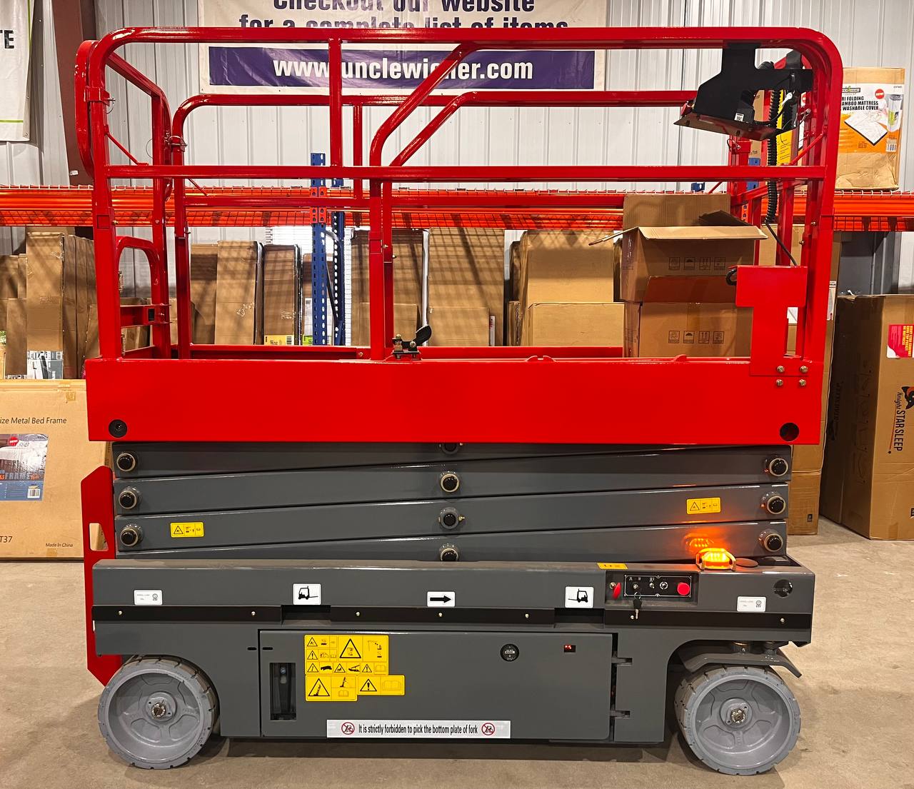 GTJZ08 Electric Scissor Lift full view in warehouse

Platform view showing foldable guardrails

Lift extended to 10M with worker on platform

Side profile highlighting tire system

Control panel and safety features close-up