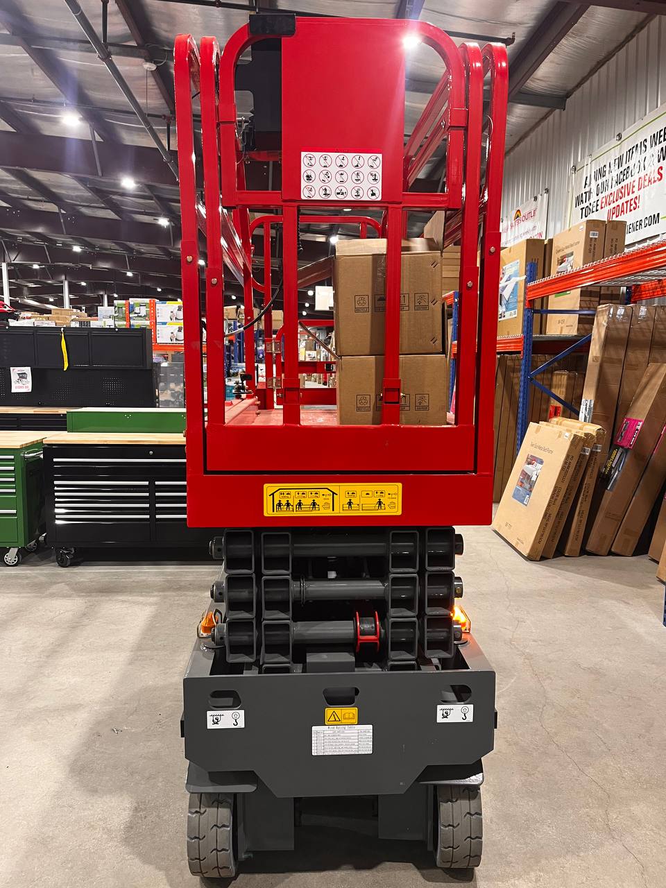 GTJZ08 Electric Scissor Lift full view in warehouse

Platform view showing foldable guardrails

Lift extended to 10M with worker on platform

Side profile highlighting tire system

Control panel and safety features close-up