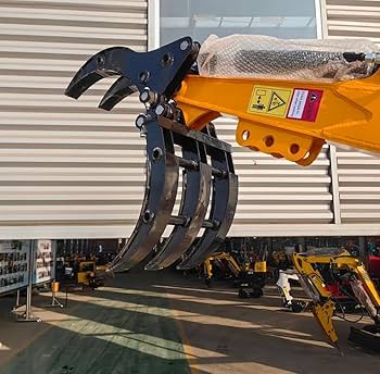 1 Ton Mini Excavator with red exterior and enclosed cab

Excavator attachments: auger, rake, ripper tooth

Briggs & Stratton engine close-up in compact excavator

Compact excavator operating on residential job site

Interior view of enclosed cab on mini excavator