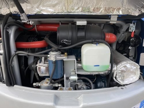 1 Ton Mini Excavator with red exterior and enclosed cab

Excavator attachments: auger, rake, ripper tooth

Briggs & Stratton engine close-up in compact excavator

Compact excavator operating on residential job site

Interior view of enclosed cab on mini excavator