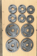 10-piece set of Olympic weight plates – 55 lb cast iron
Grip hole weight plates for Olympic barbells – black enamel finish
Heavy-duty Olympic barbell plates – commercial gym set
Close-up of cast iron 2.5 lb and 10 lb weight plates
Black Olympic weight plates stacked with 2-inch holes