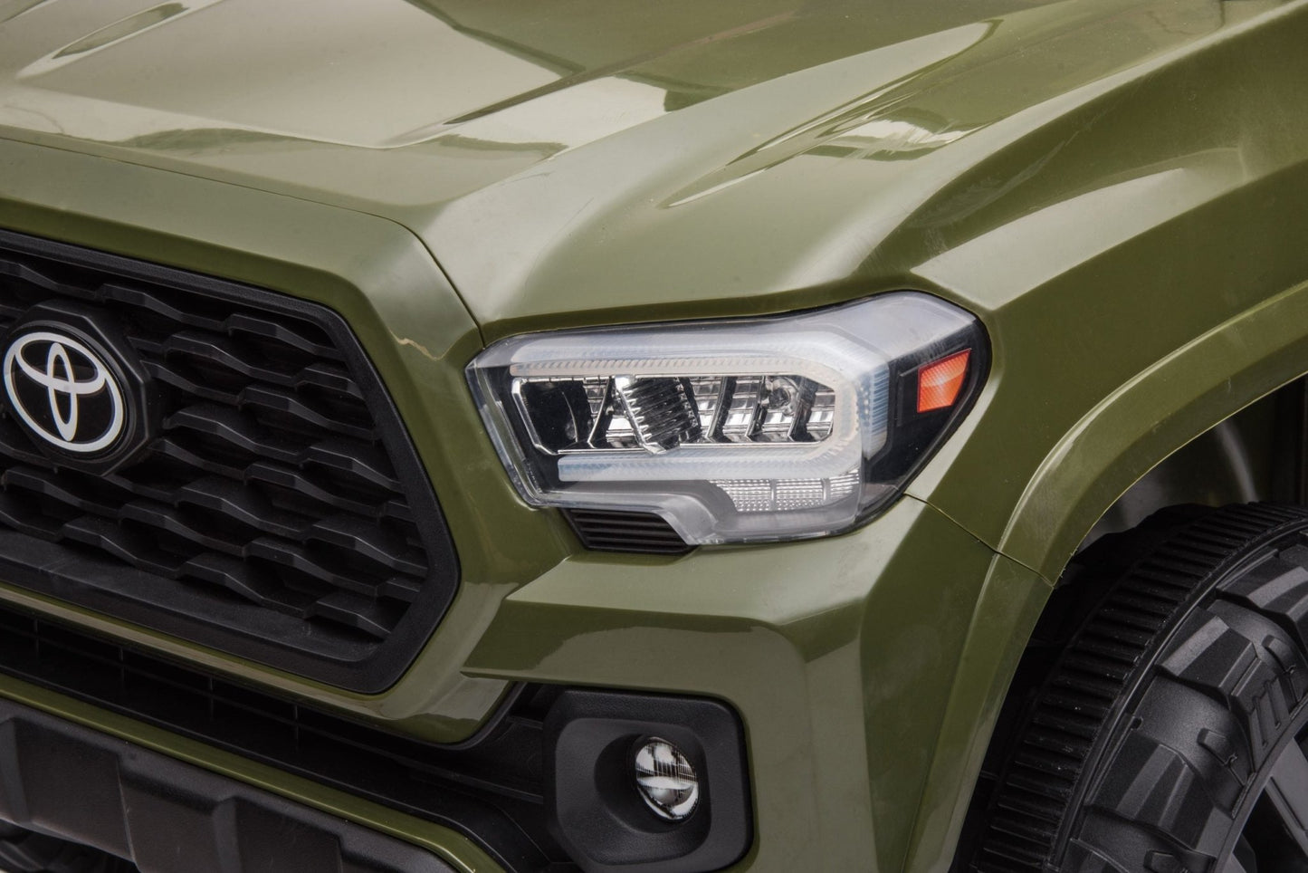 Olive green Toyota-style ride-on pickup truck for kids

Side view of remote-control kids truck with leather seat

Child’s electric ride-on truck with LED headlights

Toyota ride-on truck in olive green with suspension

Battery-powered pickup truck for toddlers