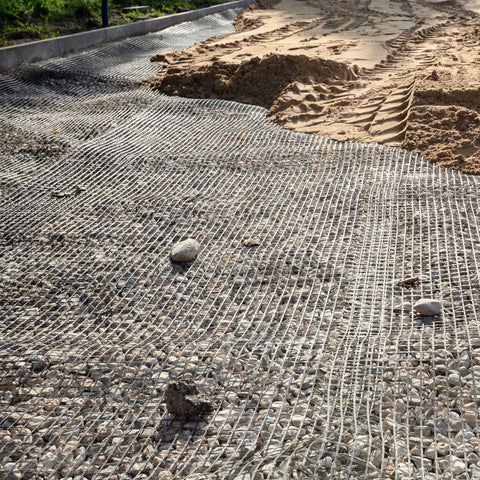 BX131X164 biaxial geogrid roll for soil reinforcement
Geogrid mesh for road base construction
Heavy-duty bidirectional geogrid unrolled on gravel
Close-up of high-tensile geogrid fabric