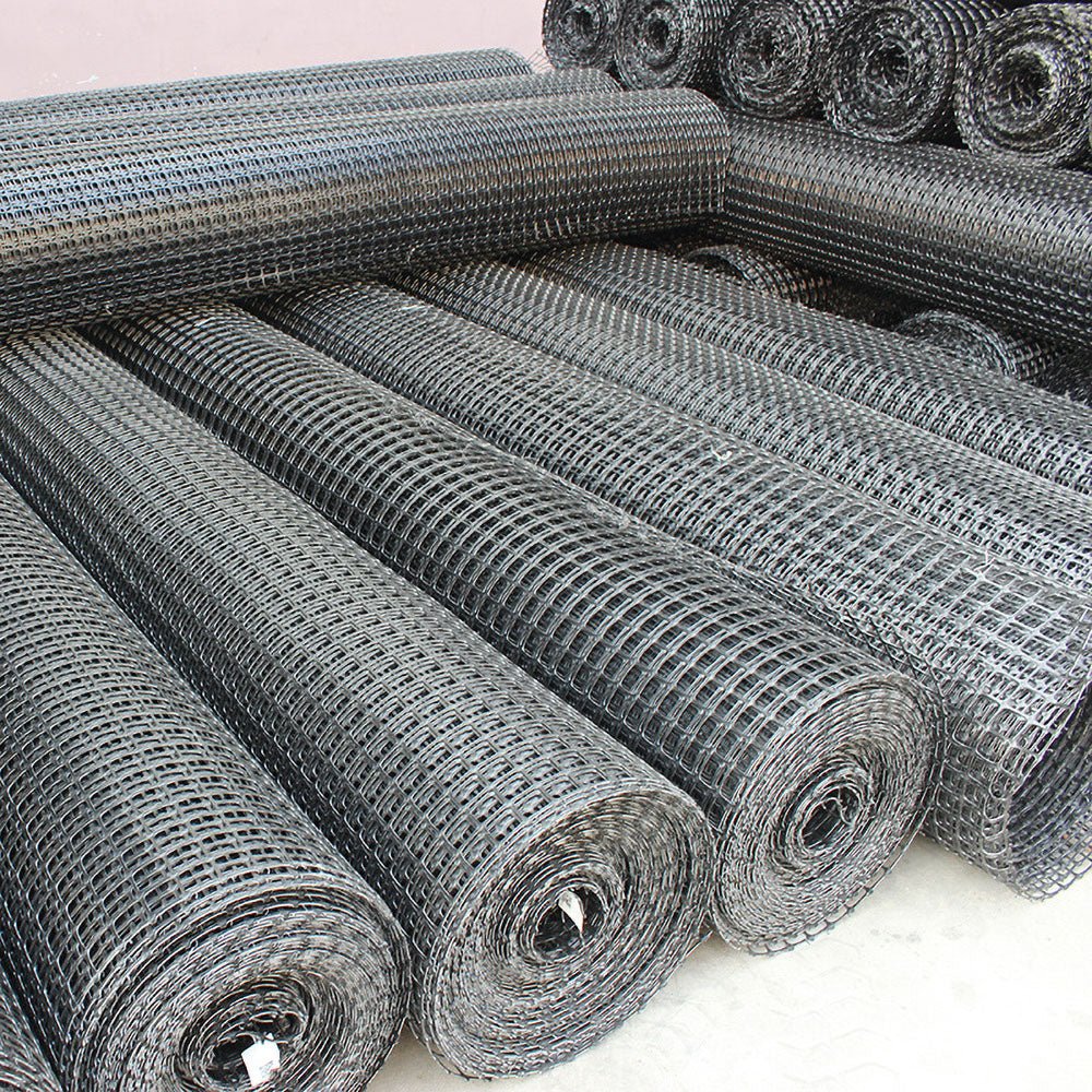 BX131X164 biaxial geogrid roll for soil reinforcement
Geogrid mesh for road base construction
Heavy-duty bidirectional geogrid unrolled on gravel
Close-up of high-tensile geogrid fabric