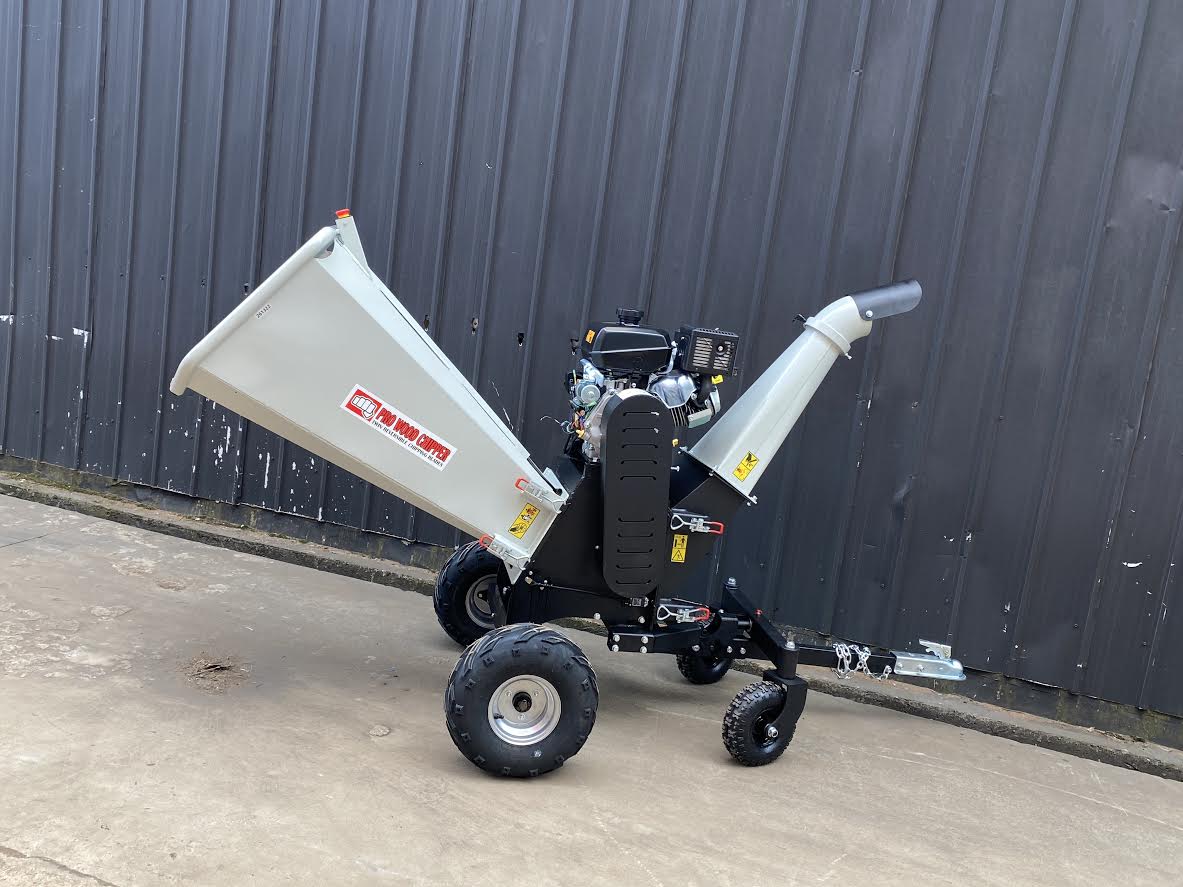 15 HP Kohler electric start wood chipper – trailer mounted front view
Side profile of 420cc wood chipper with hitch and tires
Chipper machine close-up showing large intake chute and rotor
Kohler engine wood chipper parked outdoors with debris