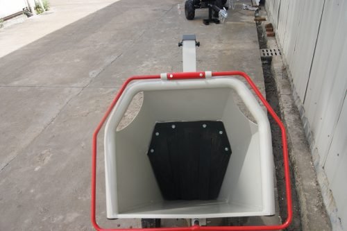 15 HP Kohler electric start wood chipper – trailer mounted front view
Side profile of 420cc wood chipper with hitch and tires
Chipper machine close-up showing large intake chute and rotor
Kohler engine wood chipper parked outdoors with debris