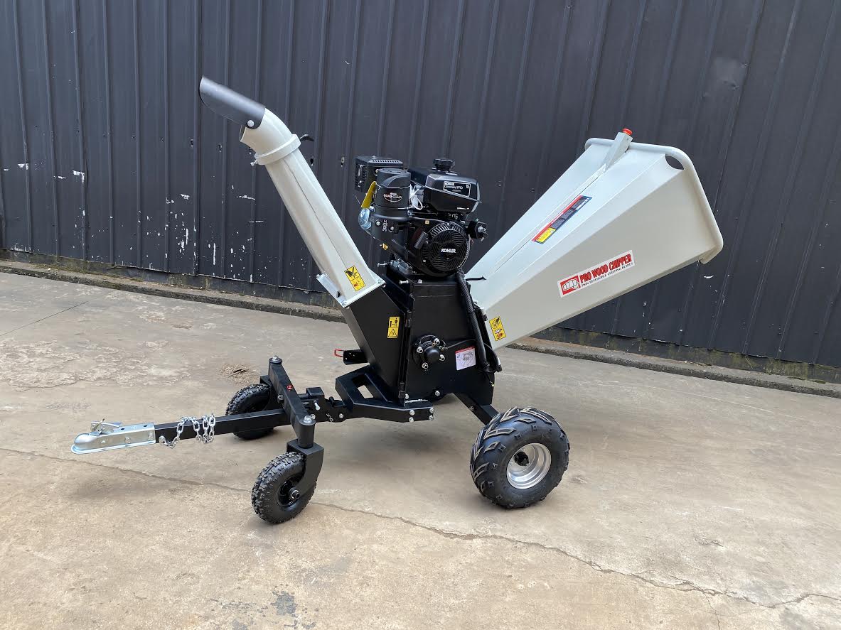 15 HP Kohler electric start wood chipper – trailer mounted front view
Side profile of 420cc wood chipper with hitch and tires
Chipper machine close-up showing large intake chute and rotor
Kohler engine wood chipper parked outdoors with debris
