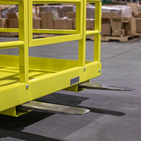 Yellow 2-person forklift safety cage with mesh floor

Forklift lifting steel work platform in industrial setting

OSHA-compliant safety cage with lockable gate

Close-up of forklift cage fork pockets and frame

Overhead maintenance platform for warehouse use