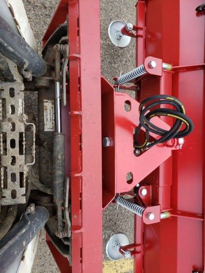Skid steer clearing snow using Bendall hydraulic snow plow

Bendall 96” red snow plow angled to the side

Close-up of adjustable skid shoes and hydraulic fittings

Rear view of snow blade attached to skid steer

Bolt-on reversible cutting edge on Bendall plow