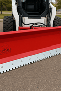 Skid steer clearing snow using Bendall hydraulic snow plow

Bendall 96” red snow plow angled to the side

Close-up of adjustable skid shoes and hydraulic fittings

Rear view of snow blade attached to skid steer

Bolt-on reversible cutting edge on Bendall plow