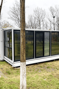 Expandable glass container house with black frame and white kitchen interior

20ft high cube glass container house on an outdoor plot

Modern prefab modular container home with large glass walls

Inside view of the container house kitchen and bathroom setup

portable luxury container home with plumbing and wiring