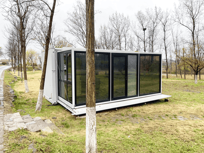 Expandable glass container house with black frame and white kitchen interior

20ft high cube glass container house on an outdoor plot

Modern prefab modular container home with large glass walls

Inside view of the container house kitchen and bathroom setup

portable luxury container home with plumbing and wiring