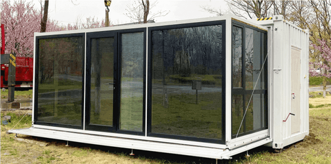 Expandable glass container house with black frame and white kitchen interior

20ft high cube glass container house on an outdoor plot

Modern prefab modular container home with large glass walls

Inside view of the container house kitchen and bathroom setup

portable luxury container home with plumbing and wiring
