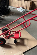Red tire trolley cart with pneumatic wheels in garage

Heavy-duty tire dolly lifting tire set, ergonomic grip detail, welded frame close-up, tire stack in transit
