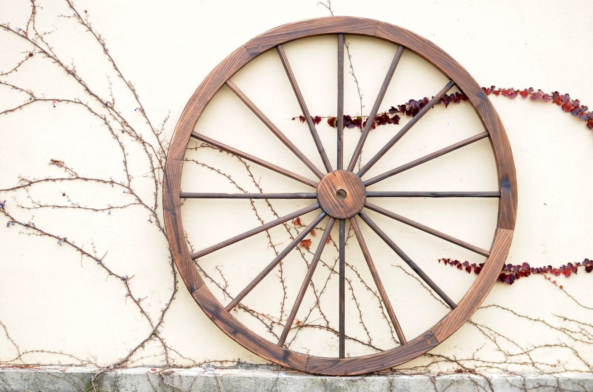 "Rustic wooden wagon wheel 48 inch for garden decor"

"Burnt wood wagon wheel leaning against a fence"

"Farmhouse yard display with decorative wooden wheels"