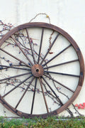 "Rustic wooden wagon wheel 48 inch for garden decor"

"Burnt wood wagon wheel leaning against a fence"

"Farmhouse yard display with decorative wooden wheels"